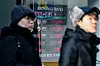 People walk past an electronic display featuring won and foreign currency exchange rates in Myeongdong, central Seoul, on Jan.1. The average won-dollar exchange rate during the fourth quarter of last year hit a record high at 1,398.75, according to data released by the Bank of Korea, the highest level since the first quarter of 2009 when the country was reeling from the financial crisis. [YONHAP]