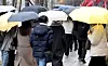People hold umbrellas under the rain on Monday. [NEWS1]