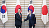 Korean President Yoon Suk Yeol, left, and Japanese Prime Minister Fumio Kishida, right, shake hands at their bilateral summit at the prime minister's residence in Tokyo on March 16. [JOINT PRESS CORPS]