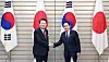Korean President Yoon Suk Yeol, left, and Japanese Prime Minister Fumio Kishida, right, shake hands at their bilateral summit at the prime minister's residence in Tokyo on March 16. [JOINT PRESS CORPS]