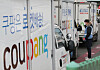 A Coupang worker talks with the company's courier in Seoul on Tuesday. Coupang said Thursday that it will distribute shares worth 2 million won ($1,800) to workers working as of March 5 as it prepares for listing on the New York Stock Exchange. [YONHAP]