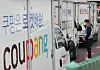 A Coupang worker talks with the company's courier in Seoul on Tuesday. Coupang said Thursday that it will distribute shares worth 2 million won ($1,800) to workers working as of March 5 as it prepares for listing on the New York Stock Exchange. [YONHAP]