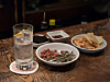 Dahee's signature gin tonic served with basic snacks such as gim (seaweed), dried anchovies, peanuts and chips. [JIN EUN-SOO]