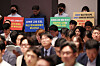 Protestors hold signs condemning the excessive regulation of the e-commerce industry during a public hearing regarding the payment crisis at TMON and WeMakePrice at the Korea Press Center in Jung District, central Seoul, on Monday. [YONHAP]