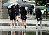 People walk in rain with umbrellas in Gwangju on Friday. [YONHAP]