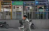 A passerby walks by ATMs in Sunday in central Seoul. The number of employees at Korea's five major commercial banks — KB Kookmin, Shinhan, Woori, Hana and NongHyup Bank — fell by more than 1,000 every year since 2018. There were a total of 69,751 employees of the five banks as of last year, down 4,444, or down 6 percent, compared to the end of 2018. [YONHAP]