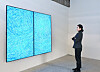 A model looks at a digital version of the iconic painting '05-IV-71 #200 (Universe)' by Korean modern art master Kim Whanki (1913-1974) on an LG OLED display at Gana Art Bogwang in Yongsan, central Seoul. [LG ELECTRONICS]