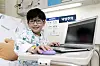 A 10-year-old boy with a rare disease, Yoon San, smiles and shows off some computer coding he did on Thursday at Seoul National University Hospital in central Seoul. [JANG JIN-YOUNG]