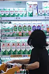 A customer looks at different milk brands displayed at a supermarket in Seoul on Wednesday. [YONHAP]