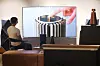 A model tests Bang & Olufsen's speaker, TV and headphones at the company's store in Gangnam District, southern Seoul. With more people staying home due to Covid-19, home theater products are gaining popularity. [YONHAP]