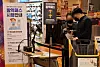 A shopper flashes a QR code to prove vaccination status upon entry to an Emart in Seoul on Wednesday. Under the strengthened vaccine pass policy, which went into effect Monday, large supermarkets and department stores require all customers to have vaccine passes for entry. [YONHAP]