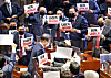 As President Moon Jae-in leaves the main hall of the National Assembly after delivering the 2021 budget speech, lawmakers of the opposition People Power Party show him protesting signs, asking 'What happened to this country?' on Wednesday. [YONHAP]