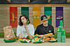 Models wear Subway-inspired clothes and eat sandwiches inside a Subway store. [FILA]