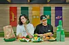 Models wear Subway-inspired clothes and eat sandwiches inside a Subway store. [FILA]