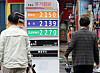 People walk past a sign board showing oil prices in Seoul on Tuesday. The Ministry of Economy and Finance announced Tuesday it would extend tax cuts on fuel for four months through August. [NEWS1]