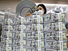 An employee organizes dollars at Hana Bank in Jung District, central Seoul, on Wednesday. According to data from the Bank of Korea, foreign exchange reserves came to $416.53 billion as of the end of July, up $5.8 billion from a month earlier. Korea's foreign exchange reserves have been increasing for four consecutive months. [YONHAP]