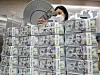 An employee organizes dollars at Hana Bank in Jung District, central Seoul, on Wednesday. According to data from the Bank of Korea, foreign exchange reserves came to $416.53 billion as of the end of July, up $5.8 billion from a month earlier. Korea's foreign exchange reserves have been increasing for four consecutive months. [YONHAP]