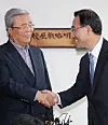Kim Chong-in, left, shakes hand with Rep. Joo Ho-young, floor leader of the United Future Party, on Friday. They agreed that Kim will head the party as interim leader until April next year.