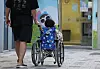 A child in a wheelchair heads toward a pediatrician's office during evening hours in Seoul on June 18. [YONHAP]