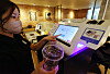 A staff member demonstrates the plastic cup recycling process at a Starbucks cafe in central Seoul on Tuesday. Recycling plastic cups using the dedicated kiosk in 42 selected cafes around the Gwanghwamun and Sungnyemun areas in central Seoul will reward the user with 100 won ($0.07). [YONHAP]