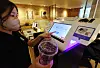 A staff member demonstrates the plastic cup recycling process at a Starbucks cafe in central Seoul on Tuesday. Recycling plastic cups using the dedicated kiosk in 42 selected cafes around the Gwanghwamun and Sungnyemun areas in central Seoul will reward the user with 100 won ($0.07). [YONHAP]