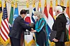 President Moon Jae-in, left, awards a state medal to the late Emil Joseph Kapaun, a U.S. Army chaplain who died in the Korean War, and presents a helmet with a cross to his nephew Ray Kapaun and his wife in a ceremony at the Blue House Tuesday recognizing two United Nations Forces veterans who fought in the war. [BLUE HOUSE]