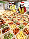Volunteers prepare sets of banchan, or side dishes, for donation in Suwon, Gyeonggi, on Tuesday. [YONHAP]
