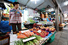 A grocery store owner looks over the vegetables while holding a fan, at a traditional market in Seoul on Sunday. Consumer prices for the month of June, which will be announced in the coming week, are expected to have increased by over 6 percent, according to market insiders. Prices will likely display a sharper hike in July and August with gas and electricity bills rising. [YONHAP]