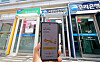 A snapshot of the newly-launched one-stop loan transfer system available via mobile app, as seen in front of ATMs installed in downtown Seoul on Wednesday. Beginning Wednesday, consumers can switch from their existing credit loans to loans offering more favorable borrowing conditions using their smartphones without having to visit a branch office of financial institutions. [YONHAP]
