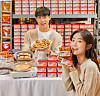 Promoters hold up vegan meat sticks and musubi made using Shinsegae Food's meat alternative Better Meat, a plant-based lunch meat, at an E-mart in Gwangjin District, eastern Seoul, on Thursday. Shinsegae Food started selling Better Meat at all E-mart stores along with three baked goods containing the meat alternative on the same day. [SHINSEGAE FOOD]