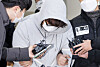 Lee Seok-joon, a 26-year-old who murdered his ex-girlfriend's mother, is questioned by reporters as he leaves the Songpa Police Precinct in Songpa District, southern Seoul, on Dec. 17, 2021. [YONHAP]