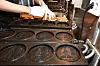 A sibwonppang store owner is making sibwonppang on the metal molds whose designs have recently come under fire by the Bank of Korea [NEWS1]