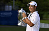 Tom Kim, also known as Kim Joo-hyung, poses with the trophy after putting in to win on the 18th green during the final round of the Wyndham Championship at Sedgefield Country Club on Aug. 7, 2022 in Greensboro, North Carolina. [GETTY IMAGES]