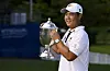 Tom Kim, also known as Kim Joo-hyung, poses with the trophy after putting in to win on the 18th green during the final round of the Wyndham Championship at Sedgefield Country Club on Aug. 7, 2022 in Greensboro, North Carolina. [GETTY IMAGES]
