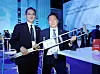 SK Group Chairman Chey Tae-won, right, holds up his crutch with the Busan World Expo printed alongside Samsung Electronics Executive Chairman Lee Jae-yong during the Korean government's expo reception dinner in Paris Wednesday. [YONHAP]