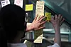 A woman attaches sticky notes with hand-written condolences on May 17 last year at Exit 10 of Gangnam Station, southern Seoul, marking four years since the murder of a 23-year-old woman by a stranger in a bathroom near the station in 2016. [NEWS1]