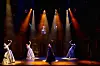 Four female cast members singing into standing microphones during a scene in the musical 'Lizze' [SHOWNOTE]