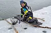 Mikael Krekula smiles after retrieving his Galaxy S23 phone from the frozen Kalix River with a fishing net affixed to a stick.[SAMSUNG NEWSROOM]