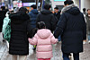 A family holds hands and walks down a street in Myeong-dong, central Seoul on Dec. 24. [NEWS1]