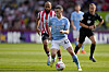 Manchester City's Phil Foden, front, duels for the ball with Brentford's Bryan Mbeumo during the Premier League match against Brentford at the Gtech Community Stadium in London on Sunday. [AP/YONHAP]