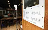 An automatic body temperature thermometer is installed at a restaurant in downtown Seoul on Aug. 28. [YONHAP]