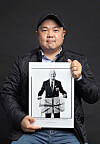 Photographer Rami Hyun, who's been taking pictures of foreign Korean War veterans since 2017, poses with one of his works — a picture of British veteran John Bowler — after an interview with the Korea JoongAng Daily at a studio in Gwanak District in southern Seoul. [PARK SANG-MOON]