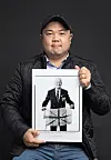 Photographer Rami Hyun, who's been taking pictures of foreign Korean War veterans since 2017, poses with one of his works — a picture of British veteran John Bowler — after an interview with the Korea JoongAng Daily at a studio in Gwanak District in southern Seoul. [PARK SANG-MOON]