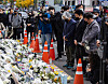 Liberal activists pay respects at a makeshift memorial altar for the victims of the Itaewon tragedy near Itaewon Station in Yongsan District, central Seoul, on Thursday. They announced plans to hold a candlelight vigil to commemorate the victims on Saturday. [YONHAP]