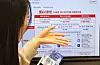 A customer looks over subscription plan choices at a SK Telecom store in Myeongdong, central Seoul, on Thursday. [YONHAP]