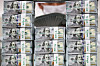An employee poses with stacks of dollar bills at a Hana Bank branch in Jung District, central Seoul, on Wednesday. According to data from the Bank of Korea, foreign exchange reserves came to $420.55 billion as of the end of September, up $1.59 billion from a month earlier. [YONHAP]