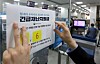 An employee posts a notice informing the public to apply for emergency government reliefs at Shinhan Bank in Jung-district, central Seoul, on May 18. [YONHAP]