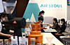 An Air Seoul employee serves inflight food at Coffee Bean's branch in Gwanghwamun, Seoul, that was redecorated to resemble the inside of a plane on Tuesday. The budget airline said it has joined hands with the coffee company to provide inflight experiences for customers who are longing for overseas trips since the Covid-19 pandemic started. Thanks to the growing number of people receiving vaccinations across the world, some countries have been opening their boarders, but the upsurge of daily cases in several countries including those in Europe means restrictions have been re-implemented, a blow to the travel industry. [YONHAP]
