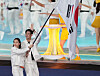 Flag bearers Kim Seo-yeong, left, and Gu Bon-gil parade into the Hangzhou Olympic Sports Center Stadium during the opening ceremony of the 19th Asian Games in Hangzhou, China on Saturday. [XINHUA]