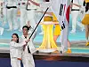 Flag bearers Kim Seo-yeong, left, and Gu Bon-gil parade into the Hangzhou Olympic Sports Center Stadium during the opening ceremony of the 19th Asian Games in Hangzhou, China on Saturday. [XINHUA]
